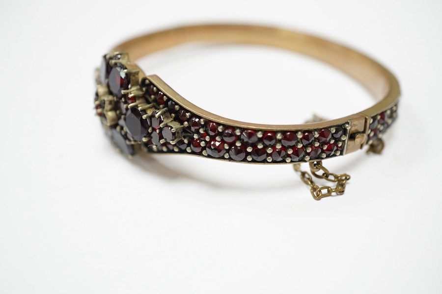 Three items of gilt white metal and garnet paste cluster set jewellery, comprising a bracelet, bangle and pair of Czechoslovakian earrings. Condition - fair